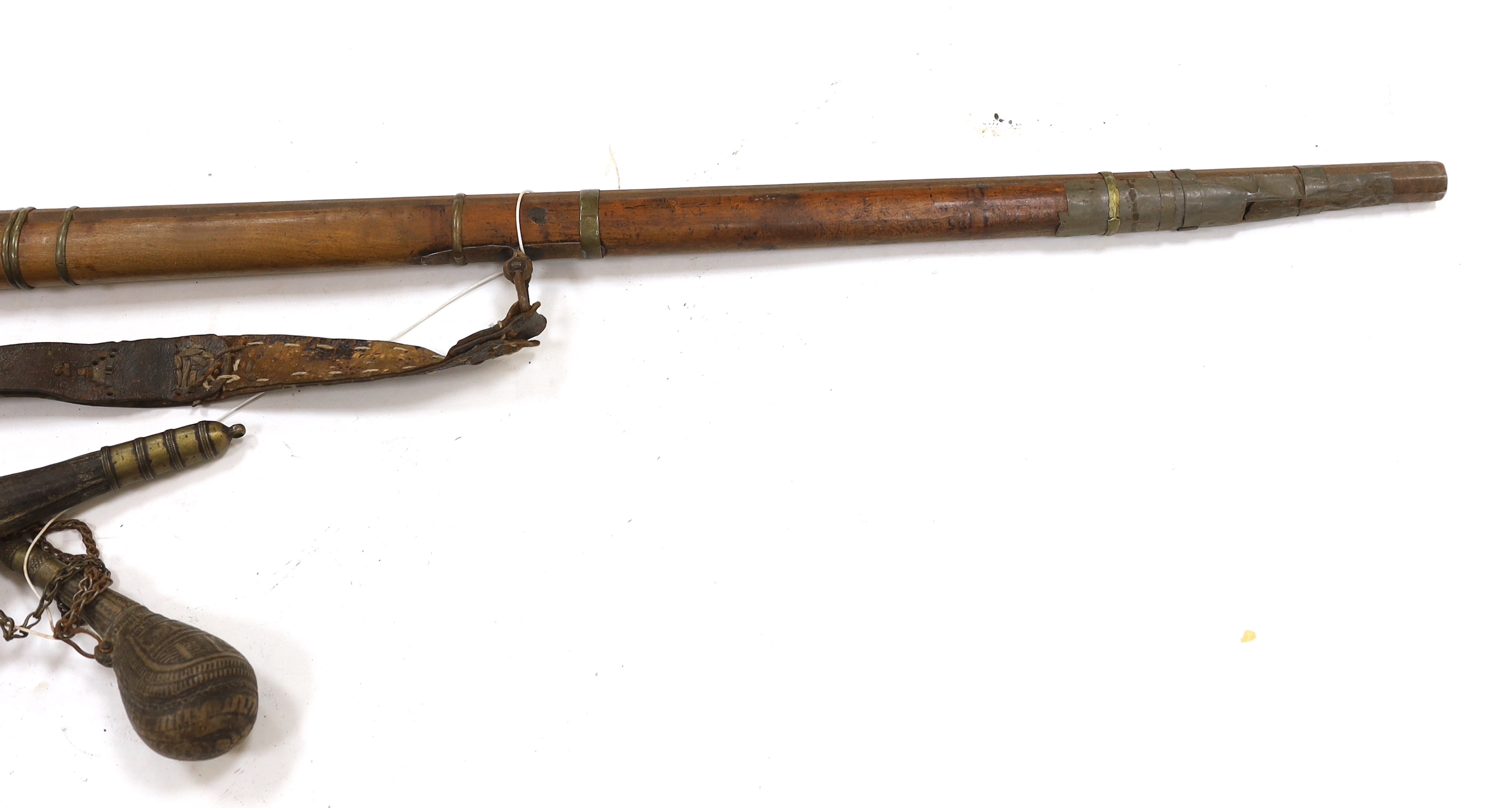 An Afghan percussion rifle with octagonal barrel and brass mounts, barrel 105.5cm, together with two leather powder flasks